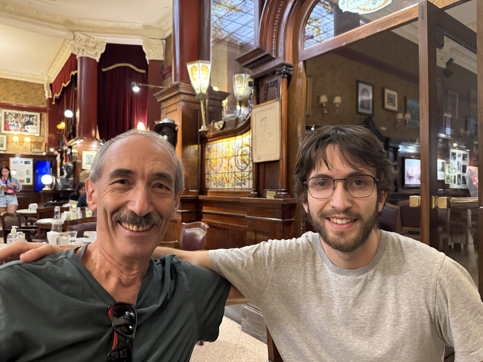 Two travelers smiling at Café Tortoni