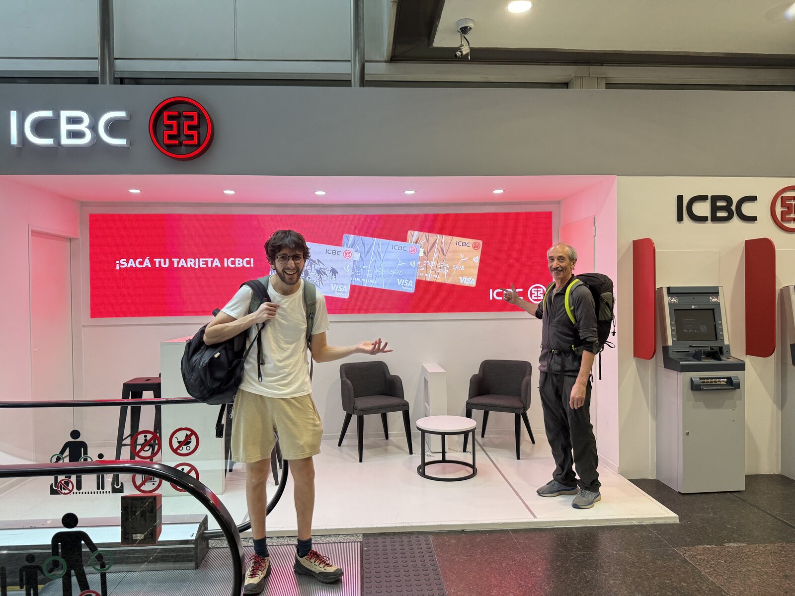 Two travelers posing at airport ICBC booth